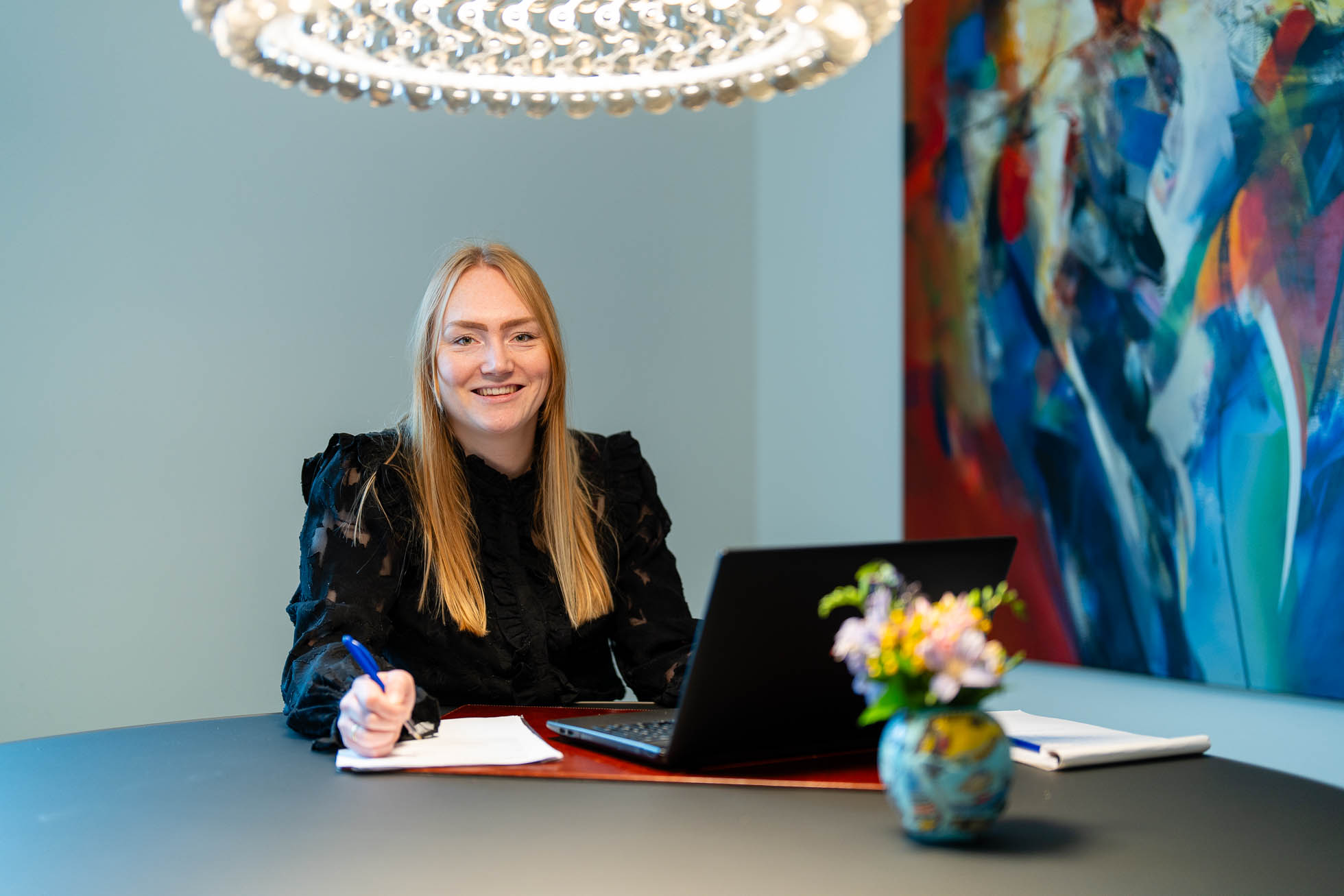 dame met laptop schrijvend op papier