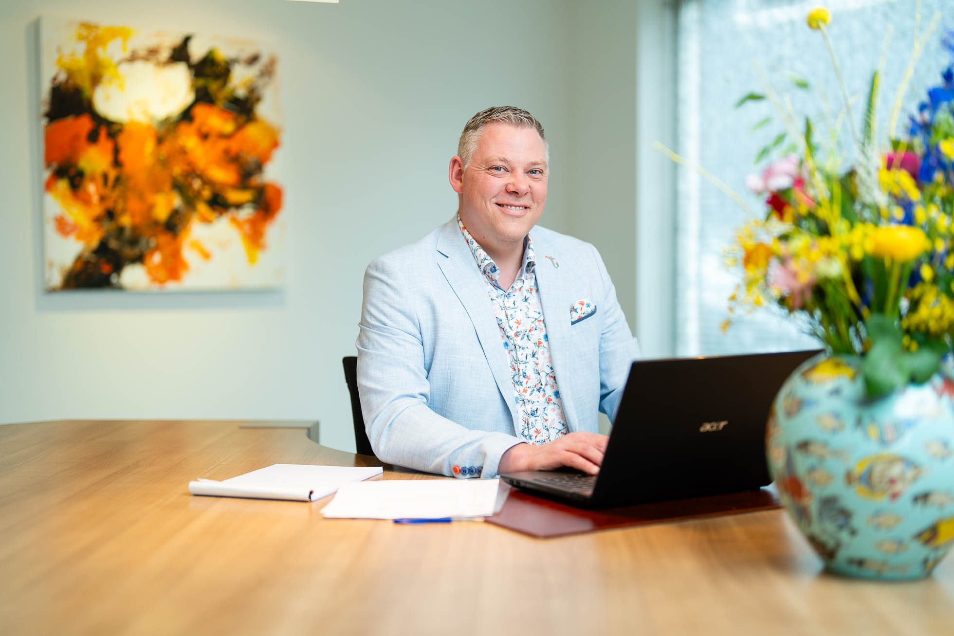 Lachende man met laptop aan het buro